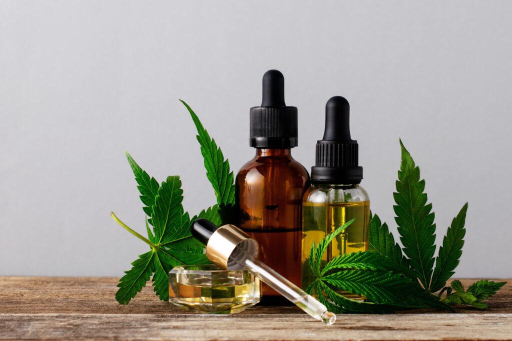 Cannabis oil in bottles on gray background with copy space. 