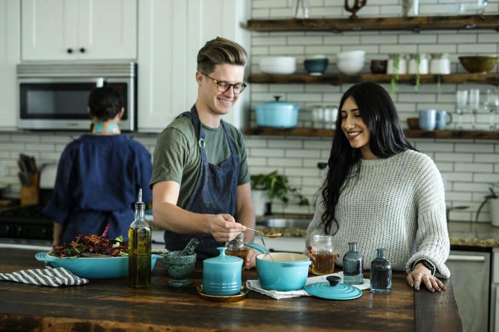 Friends cook with fresh veggies and cannabis in their kitchen.